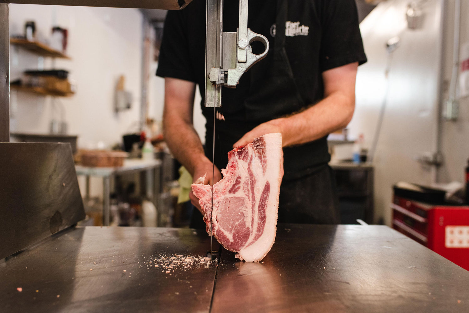 Butcher shop cutting a piece of meat for a customer