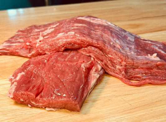 Flank Steak for sale on the counter top of a butcher shop